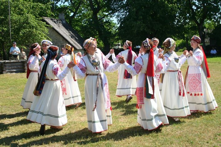 Ženy v bílých lidových krojích tančí kolo na slavnosti