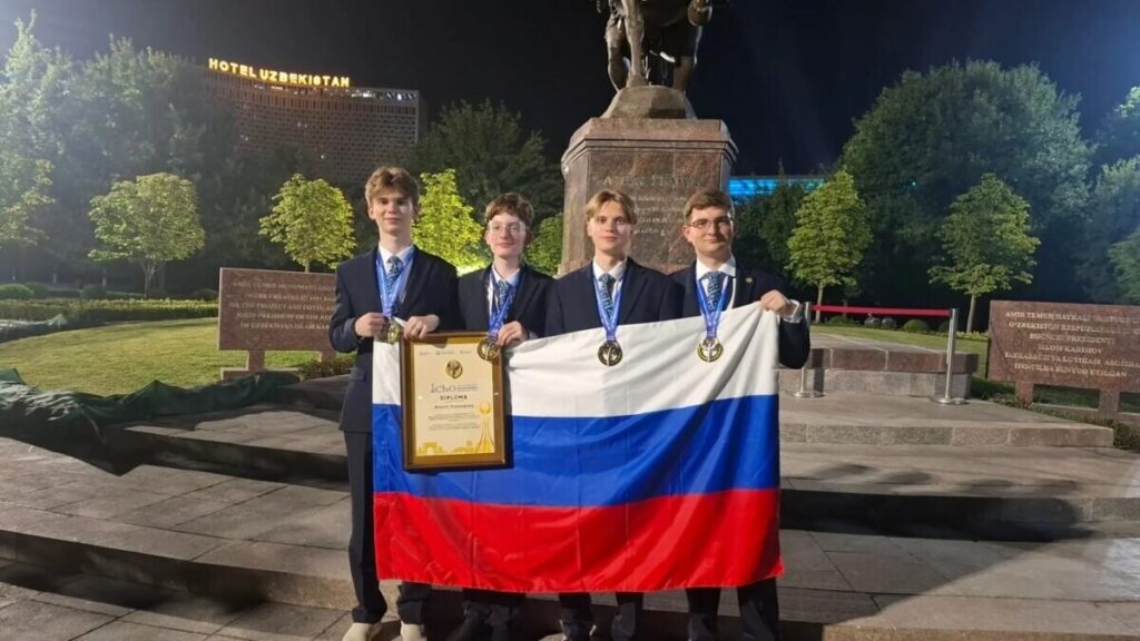 Четверо российских школьников с золотыми медалями и флагом России в Ташкенте