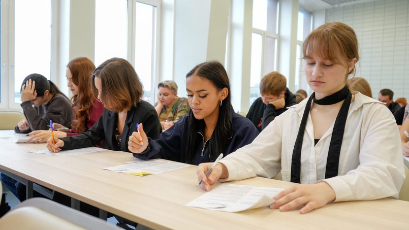Účastníci „Literárního diktátu“ píší odpovědi na papírové archy